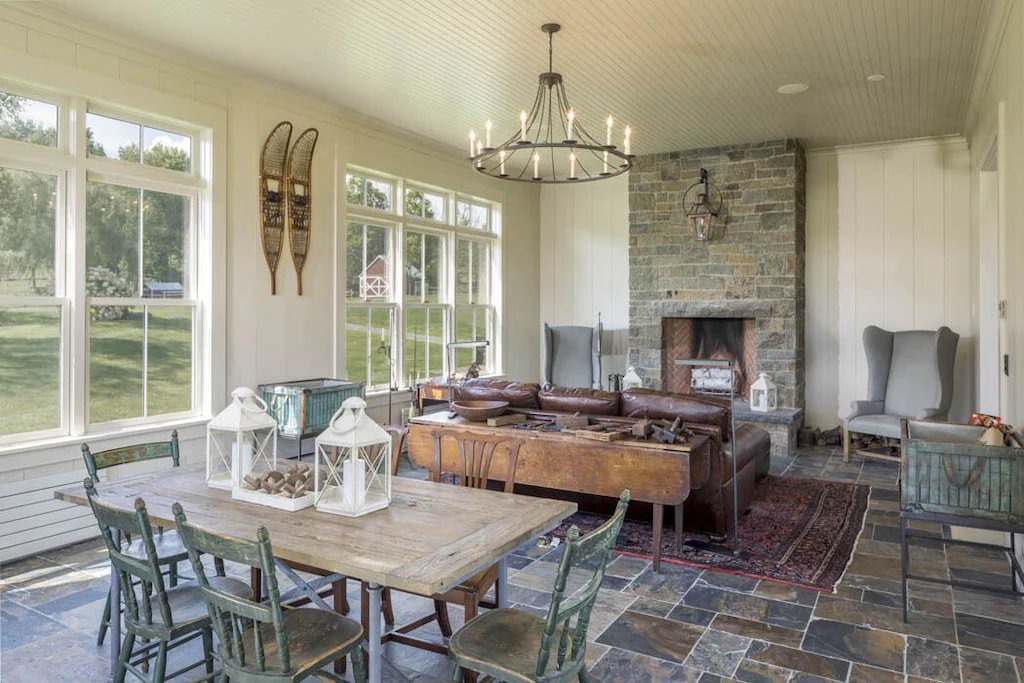 The sun room, which has large windows with stunning views and a wood burning fireplace