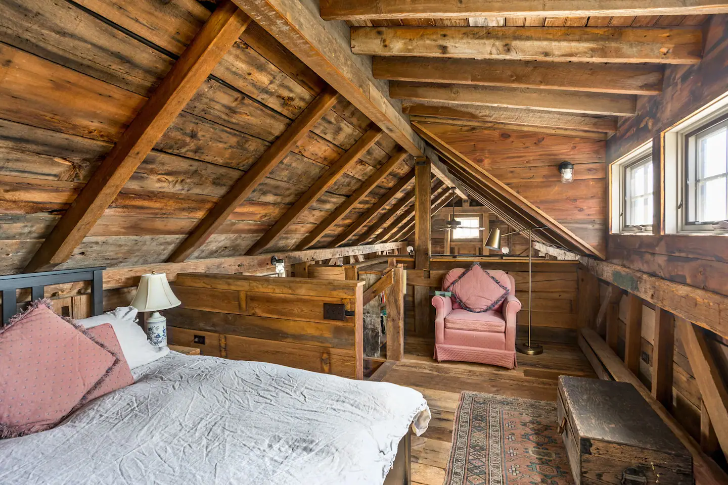 The bedroom loft of the annex includes a queen size bed and attached half-bath.