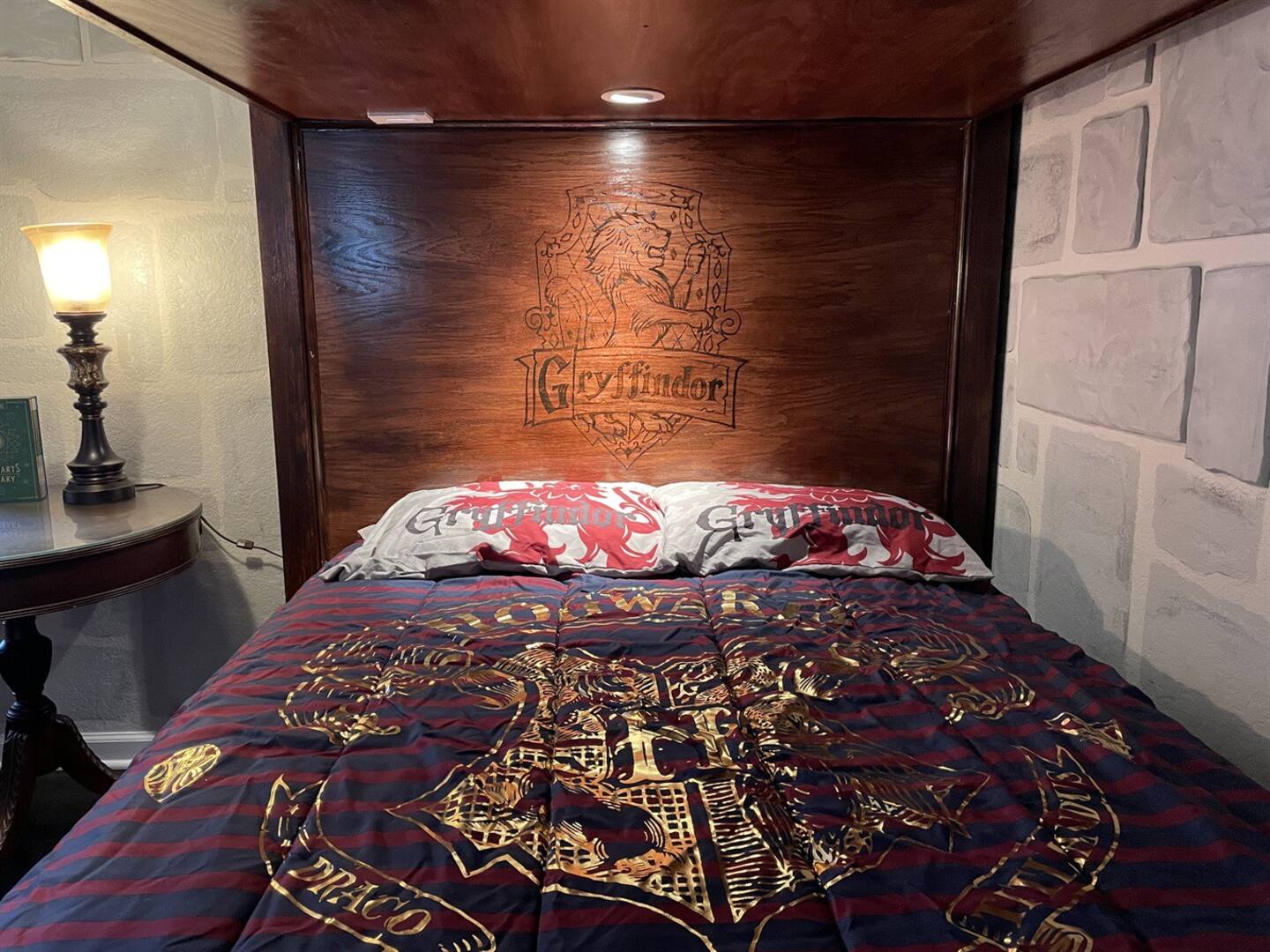 The headboard of the unique bed is engraved with the Gryffindor logo.