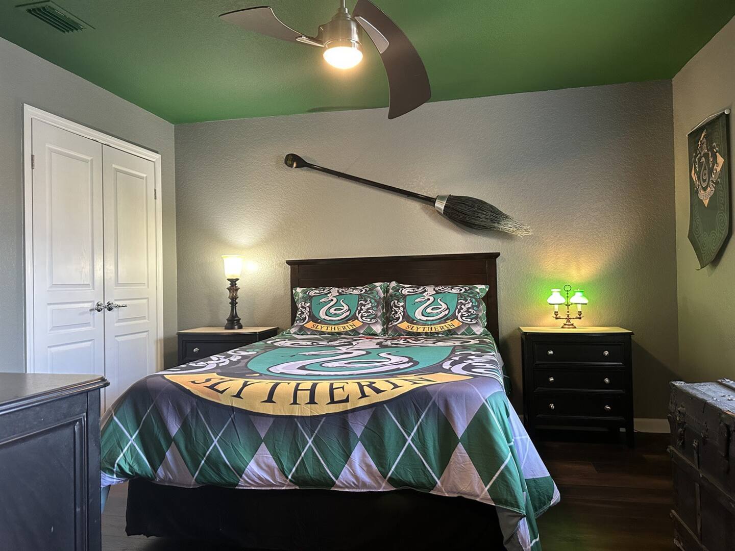 The Slytherin bedroom has a queen-size bed with a Nimbus 2001 overhead.