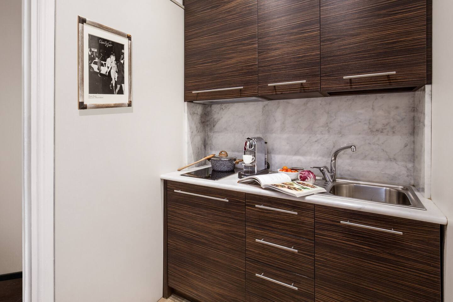 A compact kitchenette featuring a fridge, and sink.