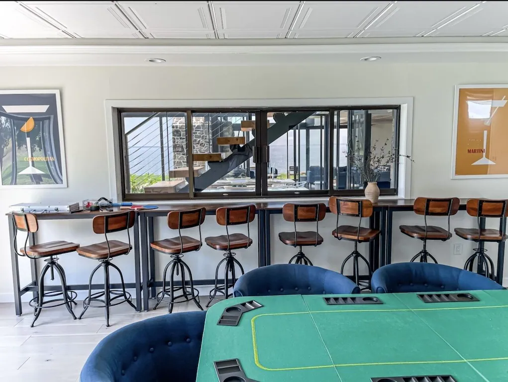 Sports room features 8 bar stools, poker table for 8, 2 65-inch TVs, foosball, and more.