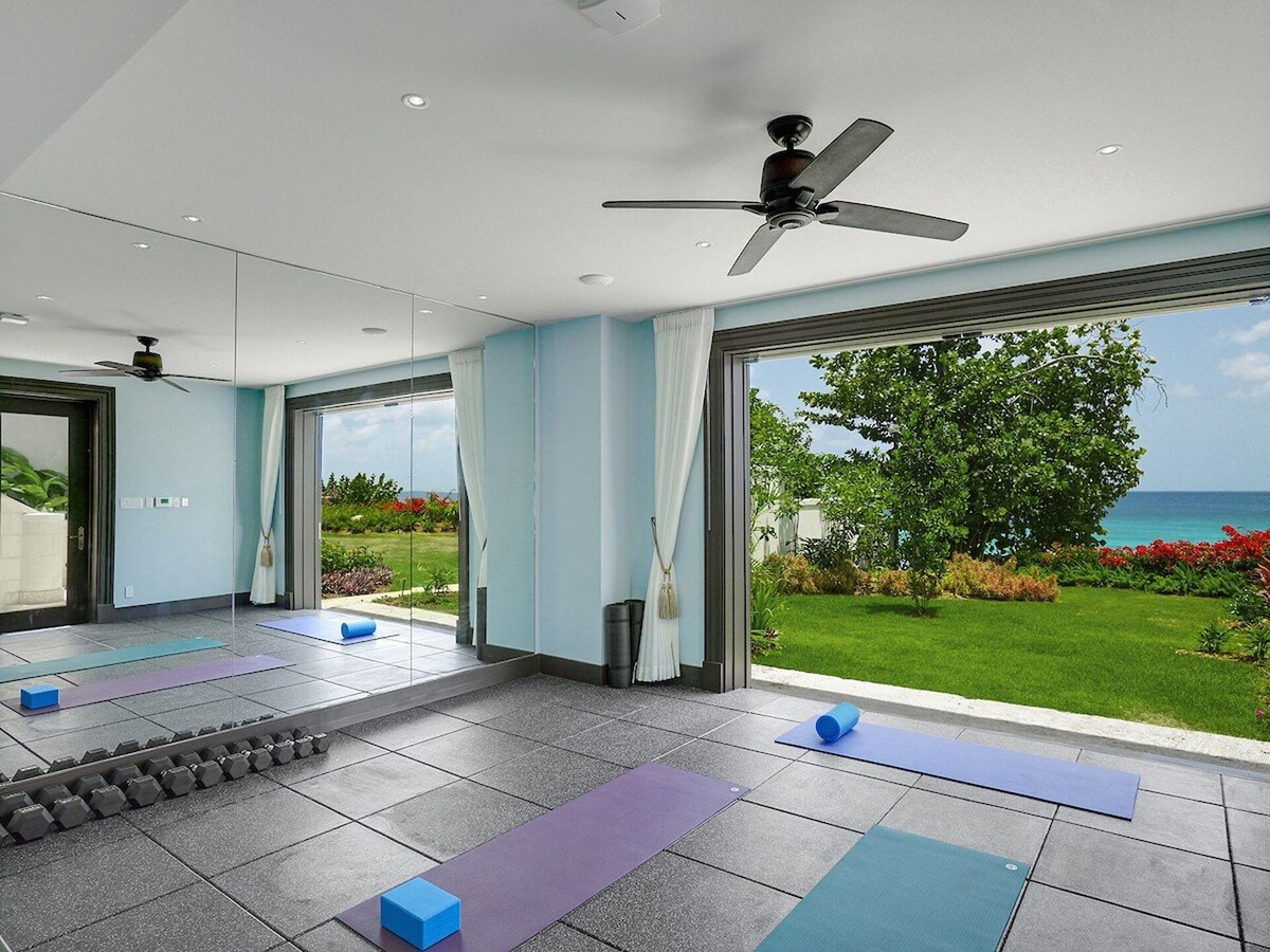 A spacious, well-lit fitness facility in a luxurious villa.
