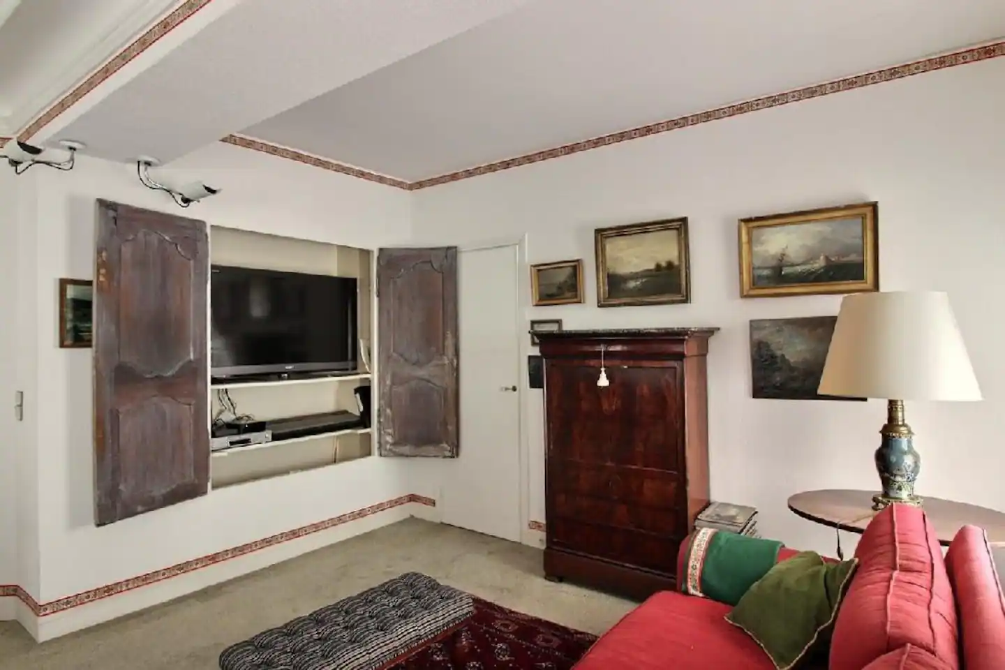 Television room, with a couch and a large TV set placed in a built-in cupboard