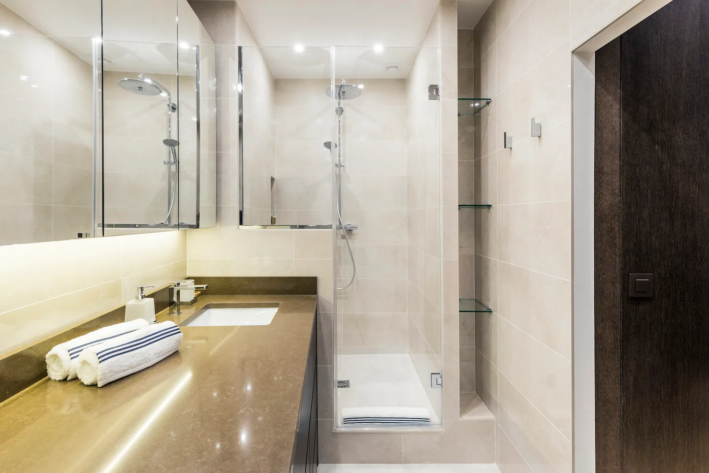Bathroom features: sink, shower, toilet, shelves, tiled floor.