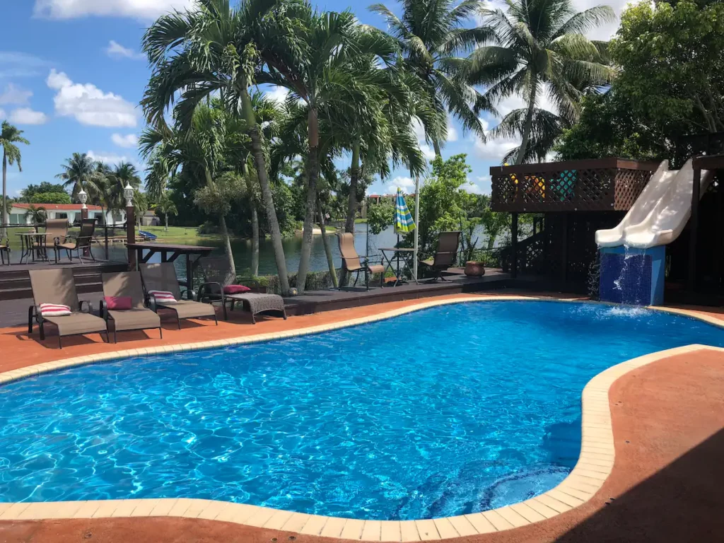 Las Palmas Miami - Heated Pool with Salt water filtering System, with Double Water Slide and Fountain, next to the Sun Beds and Lake View Area.