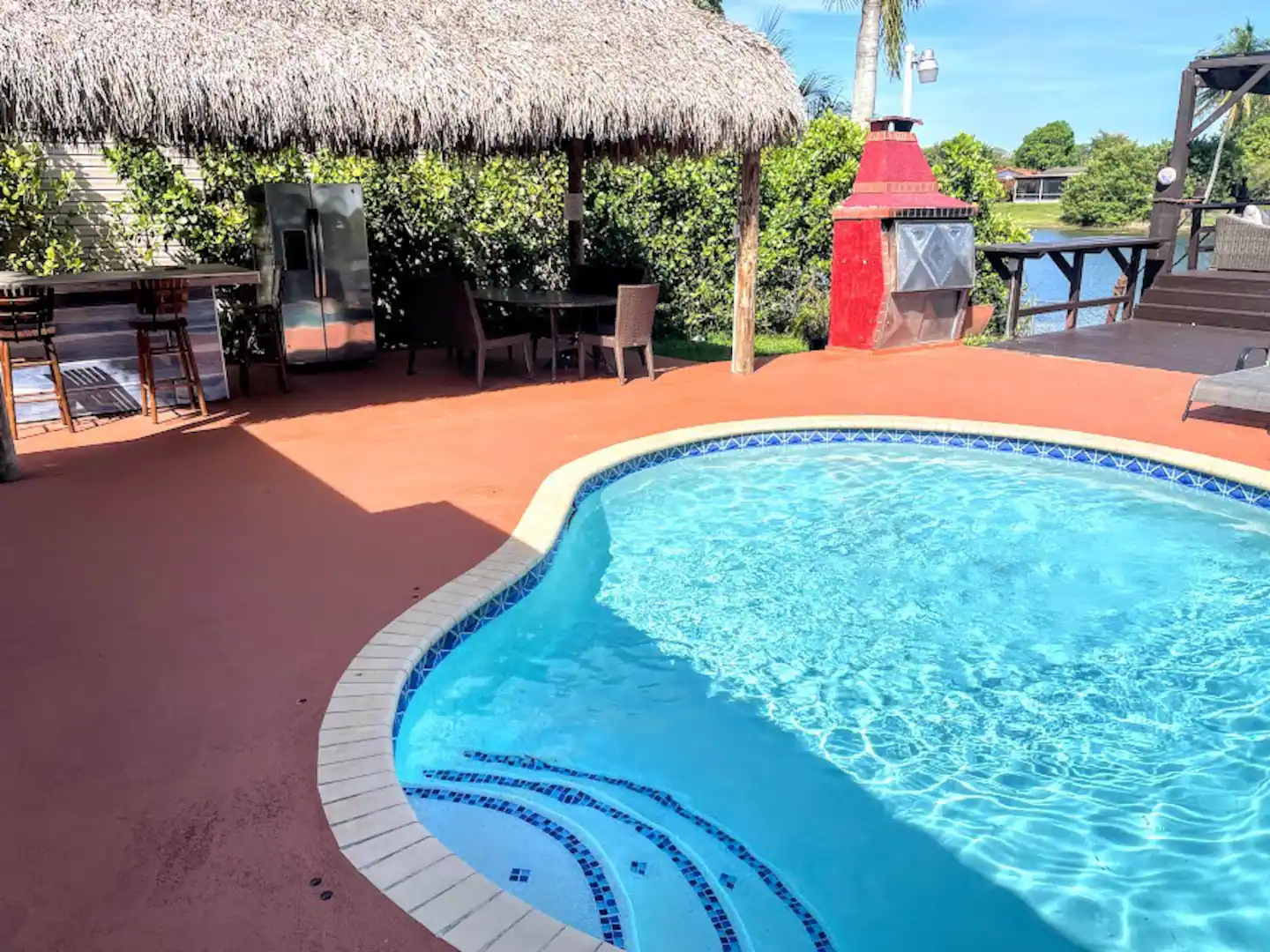 Heated pool patio, Tiki with bar, Outside Fridge, Dinning table and Large Argentinian BBQ with wooden counter, and Deck over the Lake.