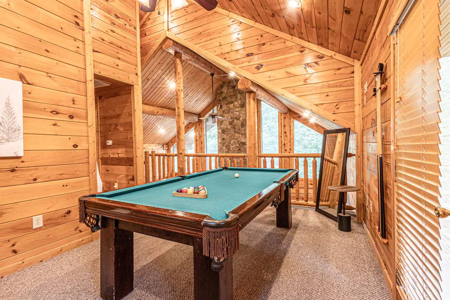 The other side of the upstairs is an open loft with a 7' slate pool table and a balcony overlooking the side deck area and thick trees.