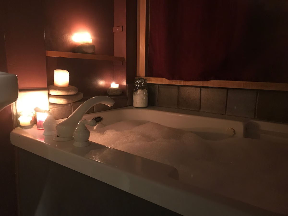 Romantic jacuzzi tub with jets, bubbles, and candles